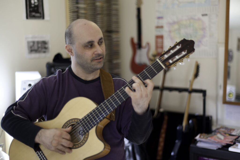 Malcolm Callus playing classical guitar in his London studio