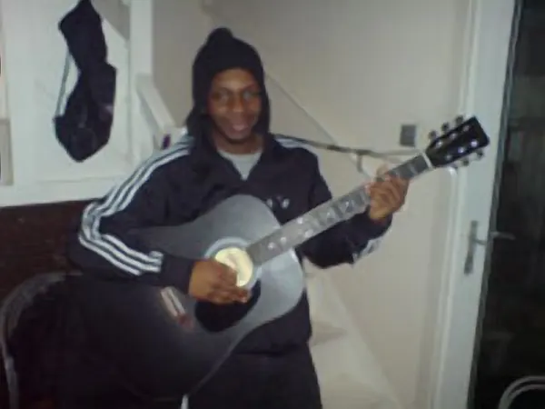 Guitar pupil Damilola Hassan and their acoustic guitar, taught by Malcolm Callus in London SE16