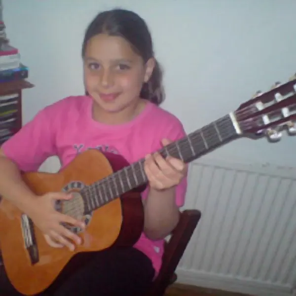Marianne Bittar holding their classical guitar — Cool Gool Music guitar lessons, London SE16