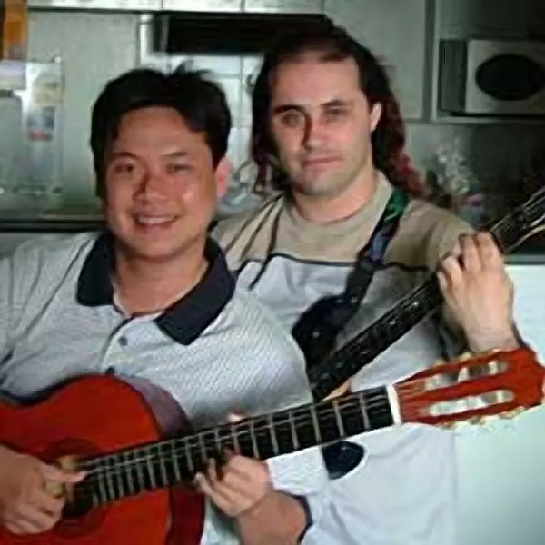 Quan Tran with the classical guitar they play in lessons at Cool Gool Music, south east London