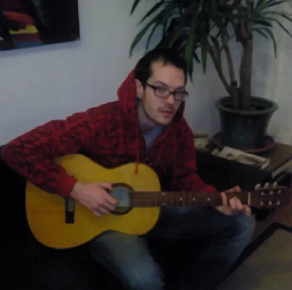 Sam Taffs holding their electric and acoustic guitar — Cool Gool Music guitar lessons, London SE16