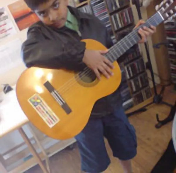 Sid the Kid with the classical guitar they play in lessons at Cool Gool Music, south east London