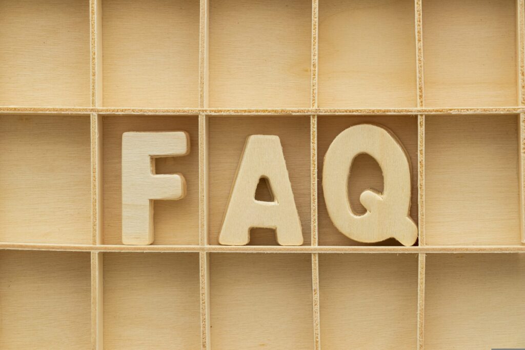Wooden letters spelling FAQ laid out in a wooden compartment tray